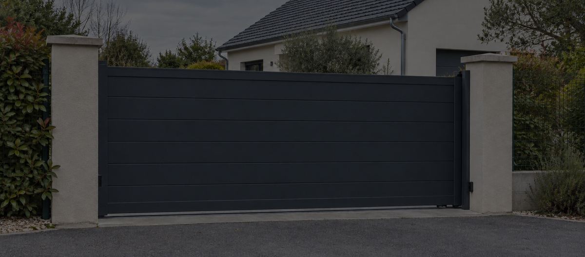 Portail coulissant en aluminium anthracite devant une maison.